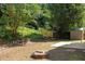 Private backyard with wooded border, fire pit, storage shed, and mature trees at 103 Burham Ct, Apex, NC 27502