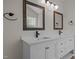 Bathroom with double sink vanity, black fixtures, framed mirrors, and overhead lighting at 103 Burham Ct, Apex, NC 27502