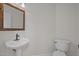 Cozy half bathroom with pedestal sink, decorative mirror, and white fixtures at 103 Burham Ct, Apex, NC 27502