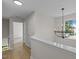 The upstairs hallway includes light hardwood floors and a stylish chandelier at 103 Burham Ct, Apex, NC 27502
