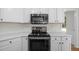 Kitchen features white cabinetry, stainless microwave, and cooktop at 103 Burham Ct, Apex, NC 27502