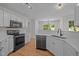 Bright kitchen features white cabinets, stainless appliances, and quartz countertops at 103 Burham Ct, Apex, NC 27502