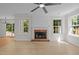 Bright living room features a fireplace, ceiling fan, and views to the outside at 103 Burham Ct, Apex, NC 27502