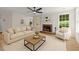 Bright living room features a fireplace, ceiling fan, and an open floorplan with wood floors at 103 Burham Ct, Apex, NC 27502