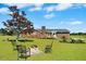 The backyard features a fire pit with chairs, a large tree, and the house in the background at 1035 Aquilla Rd, Benson, NC 27524