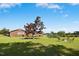 A spacious backyard with green grass, landscaping, and a fire pit seating area at 1035 Aquilla Rd, Benson, NC 27524