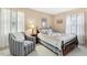 Bright bedroom with a striped chair and a comfortable bed near windows with blue curtains at 1035 Aquilla Rd, Benson, NC 27524