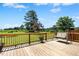A wooden deck with a swing overlooks the expansive yard and lush greenery beyond the railing at 1035 Aquilla Rd, Benson, NC 27524