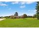 A ranch-style home with a brick facade, large front yard, mature trees, and well-maintained landscaping at 1035 Aquilla Rd, Benson, NC 27524