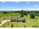 A ranch-style home with a brick facade, large front yard, mature trees, and a backdrop of lush greenery at 1035 Aquilla Rd, Benson, NC 27524