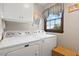 Well-equipped laundry room with modern appliances, overhead storage, and a window at 1035 Aquilla Rd, Benson, NC 27524