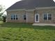 Nice backyard featuring a lush green lawn and a charming brick house with multiple windows and a door at 1042 Tulloch Court Ct # 213, Burlington, NC 27215