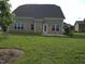 Spacious backyard with green lawn, beautiful brick house, patio, and mature tree at 1042 Tulloch Court Ct # 213, Burlington, NC 27215