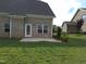 View of the backyard featuring a lush green lawn and a charming brick house with a patio at 1042 Tulloch Court Ct # 213, Burlington, NC 27215