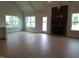 Open-concept living room with a stone fireplace, large windows, and hardwood floors, creating a warm atmosphere at 1042 Tulloch Court Ct # 213, Burlington, NC 27215