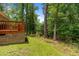 Backyard with a deck, grass, mature trees, and green surroundings at 1051 Upland Reach, Sanford, NC 27332