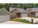 Charming brick townhome featuring an attached garage, landscaped lawn, and inviting front entrance at 1051 Upland Reach, Sanford, NC 27332