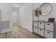 Inviting hallway with light wood floors, storage console, and round mirror at 1051 Upland Reach, Sanford, NC 27332