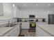 Bright kitchen features stainless appliances, white cabinets and modern lighting at 1051 Upland Reach, Sanford, NC 27332