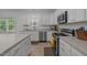 Well-lit kitchen features stainless appliances, white cabinets, and countertops at 1051 Upland Reach, Sanford, NC 27332