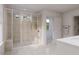 Bright bathroom featuring a glass enclosed shower with built-in bench and neutral tile at 1053 Hardin Hill Ln, Knightdale, NC 27545