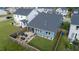 Aerial view of a fenced backyard featuring a stone patio with comfortable seating and a well-manicured lawn at 1104 Briar Gate Dr, Holly Springs, NC 27540