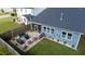 Landscaped backyard featuring a stone patio with a seating, dining area, and a neatly kept lawn at 1104 Briar Gate Dr, Holly Springs, NC 27540