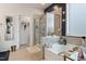 Stylish bathroom featuring a soaking tub, glass-enclosed shower, and a doorway with modern geometric decorations at 1104 Briar Gate Dr, Holly Springs, NC 27540