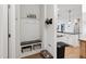 Functional entryway with a built-in bench, storage baskets, and a view of a modern kitchen, enhancing organization at 1104 Briar Gate Dr, Holly Springs, NC 27540