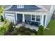Charming front porch with stone pillars and beautifully landscaped front yard at 1104 Briar Gate Dr, Holly Springs, NC 27540