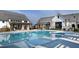 Refreshing community pool surrounded by lounge chairs, lush greenery, and modern architectural buildings at 113 Seagraves Creek Ln, Holly Springs, NC 27540