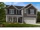 New construction gray two-story home with a two-car garage and covered porch at 113 Seagraves Creek Ln, Holly Springs, NC 27540