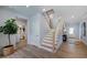 Inviting foyer with light wood floors and a staircase leading to the upper level, showcasing a modern design at 113 Seagraves Creek Ln, Holly Springs, NC 27540