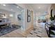 Bright hallway featuring hardwood floors, a view to the living room, and an adjacent office with french doors at 113 Seagraves Creek Ln, Holly Springs, NC 27540