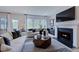 Cozy living room features a fireplace, hardwood floors, and large windows for natural light at 113 Seagraves Creek Ln, Holly Springs, NC 27540
