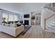Bright and open living room with hardwood floors, a fireplace, and a view of the staircase at 113 Seagraves Creek Ln, Holly Springs, NC 27540
