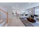 Open-concept living space with hardwood floors and seamless transition to the staircase and kitchen at 113 Seagraves Creek Ln, Holly Springs, NC 27540