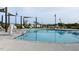 Sparkling community pool with sunshades, lounge chairs and a pool lift on a sunny day at 113 Seagraves Creek Ln, Holly Springs, NC 27540