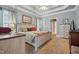 Comfortable bedroom featuring a tray ceiling, neutral carpet, and a connecting ensuite bathroom at 1149 The Preserve Trl, Chapel Hill, NC 27517