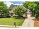 Charming brick home with a three-car garage, mature flowering tree, and well-manicured lawn at 1149 The Preserve Trl, Chapel Hill, NC 27517