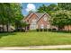 Charming two-story brick home featuring a lush green lawn and meticulously landscaped front yard at 1149 The Preserve Trl, Chapel Hill, NC 27517