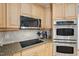 Kitchen stainless steel microwave, stovetop, oven and light wood cabinets at 1149 The Preserve Trl, Chapel Hill, NC 27517