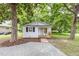 Well-maintained home with a charming front porch, gravel driveway, and mature shade trees at 121 Lena Ct, Burlington, NC 27217