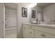 Bright bathroom featuring dual sinks, white cabinets, quartz counters, and a tiled shower at 1216 Hardin Hill Ln, Knightdale, NC 27545