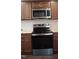 Modern kitchen with stainless steel appliances, warm wooden cabinetry, and sleek countertops at 126 Kipling Dr, Oxford, NC 27565