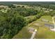 Aerial of home with fenced yard, firepit, and playhouse; surrounded by trees and pond views at 130 Ruby Trl, Roxboro, NC 27574