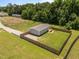 Aerial view of a home with a fenced-in yard and a gravel driveway at 130 Ruby Trl, Roxboro, NC 27574