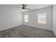 This carpeted bedroom features two windows and a ceiling fan at 130 Ruby Trl, Roxboro, NC 27574