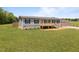 Single-story home with a cozy front porch and a large grassy yard at 130 Ruby Trl, Roxboro, NC 27574