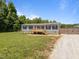 Home with a wooden porch, classic shutters, and gravel driveway at 130 Ruby Trl, Roxboro, NC 27574